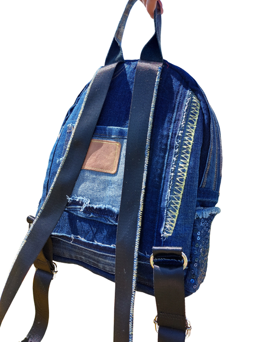 Handmade blue denim backpack with straps on a white background