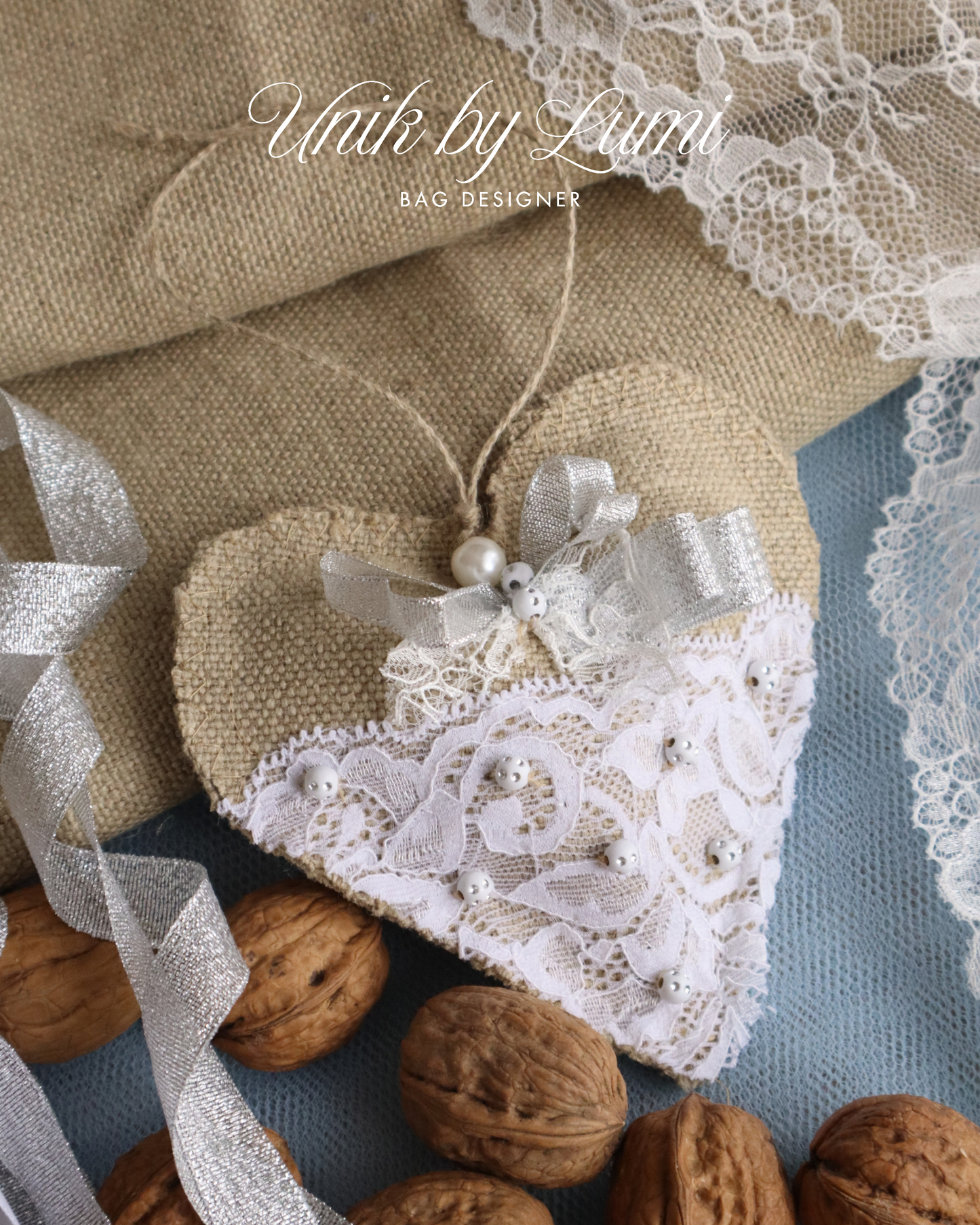Heart-shaped fabric pouch with lace details on a surface with walnuts and ribbons.