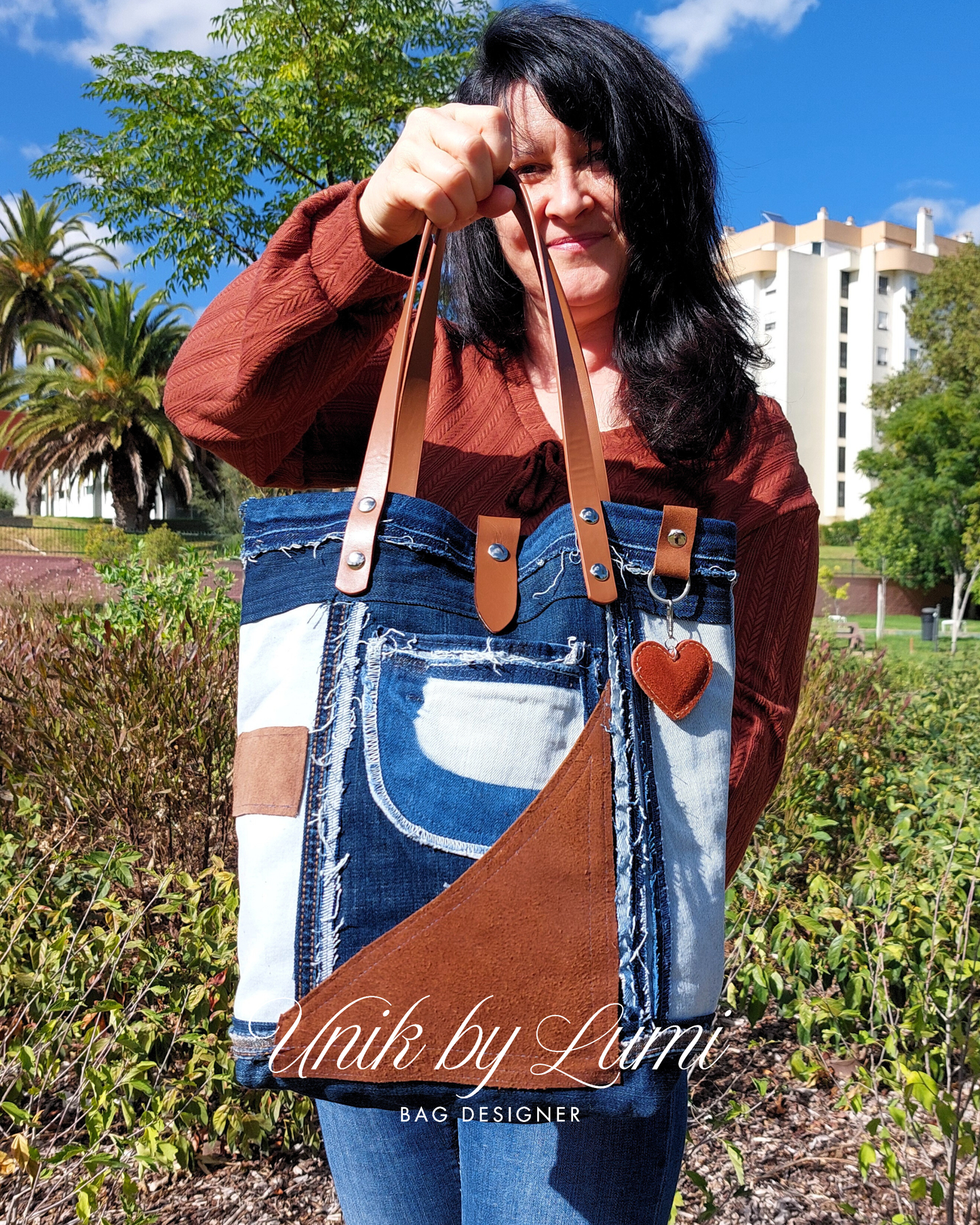 Lumi holding a handmade denim and leather tote bag